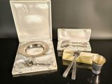 a silver plate with a spoon and spoon rest in a box
