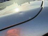 un gros plan du capot d'une voiture, éclairé par le soleil