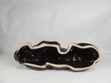 black and white ceramic sculpture of a shell shaped object on a white surface