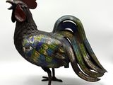 une statue représentant un coq posé sur une surface blanche