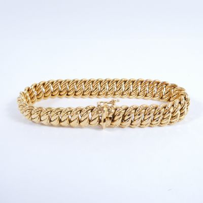 a close up of a gold bracelet on a white background