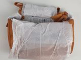 a roll of toilet paper wrapped in plastic on a white surface