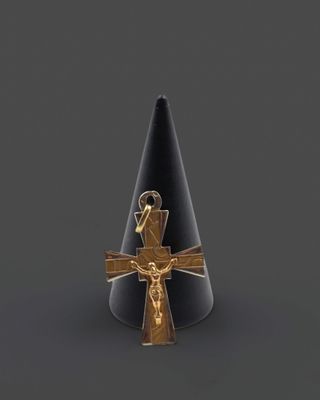 un chapeau noir surmonté d'une croix dorée