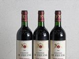 trois bouteilles de vin posées sur une table en bois