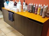 many bottles of shampoos on the counter in the bathroom