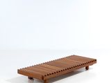 un banc en bois posé sur une surface blanche