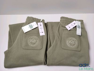 two pairs of men ' s pants with tags on them sitting on a table