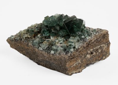 a piece of rock with green crystals on top of it