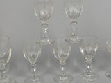 seven wine glasses sitting on a table next to each other