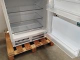 an open refrigerator sitting on a pallet in a room