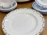 many plates and spoons on the table with silverware