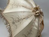 un parapluie blanc orné d'un ruban marron