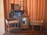 a small table with a clock and a chair in front of an orange curtain