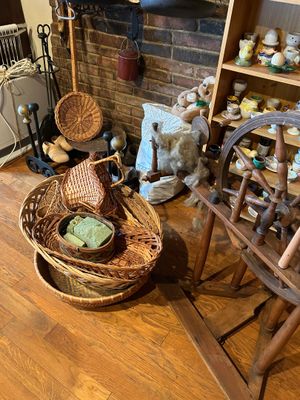 une pièce avec une cheminée, un fauteuil, un panier et d'autres objets posés par terre
