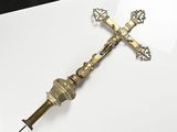 brass crucift on a white surface with a black background