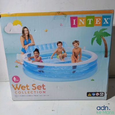 three children sitting in an inflatable pool with a palm tree