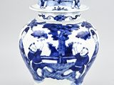 a blue and white vase with a lid on a table