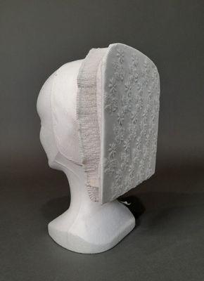 la tête d'un mannequin coiffée d'un chapeau en dentelle blanche