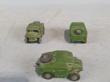 four toy army vehicles sitting on a white surface