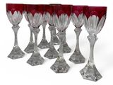 six red wine glasses sitting on top of each other on a white surface