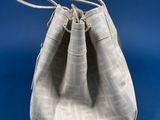 a small white bag with a white handle on a blue background