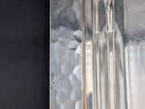 a silver plate on a black table with a black background
