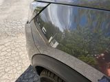a reflection of a person taking a picture of a car