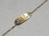 an image of a gold plated bracelet with a chain attached to it