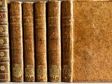 plusieurs vieux livres posés les uns sur les autres sur une table