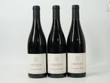 three bottles of wine are lined up on a white surface