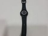the back of a watch with a black band and a white face