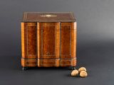 une petite armoire en bois avec deux écrous par terre