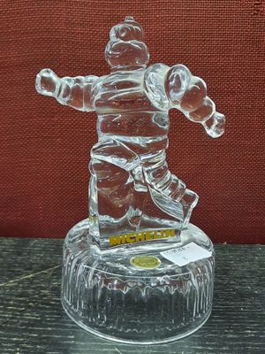 une figurine en verre représentant un homme sur un socle