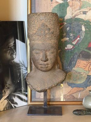a picture of a statue on a table next to a picture of a woman