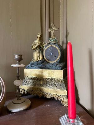une horloge et une bougie posées sur une table dans une pièce