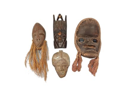 three wooden masks are sitting on a white surface