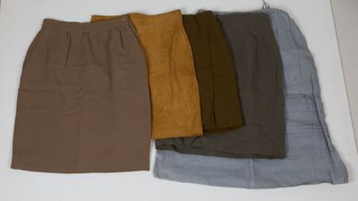 Quatre jupes de couleurs différentes sont alignées sur une surface blanche