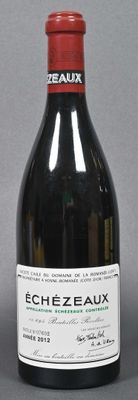 bottle of red wine with a red cap on a grey background
