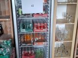 a refrigerator that has a lot of bottles of soda in it