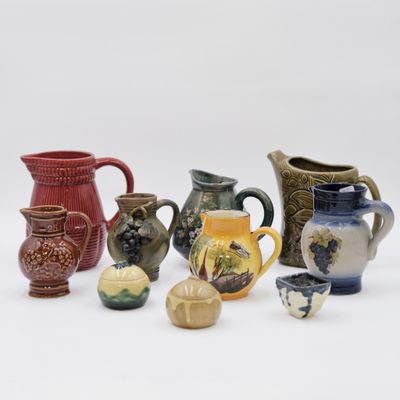 many different types of vases and pitchers on the table