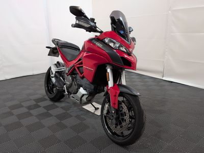 une photo d'une moto rouge garée dans une pièce