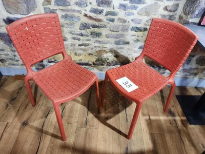 deux chaises rouges placées l'une à côté de l'autre sur un parquet