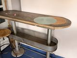 une table sur laquelle est posé un skateboard, dans une pièce