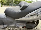 a scooter that is parked on the gravel