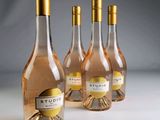 Trois bouteilles de vin rosé sont alignées sur une table