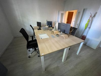 un bureau avec deux ordinateurs et une chaise dans une pièce