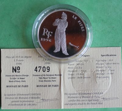 a silver coin with a picture of a man holding a baseball bat