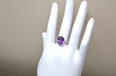 an amethorate and diamond ring on a mannequin hand