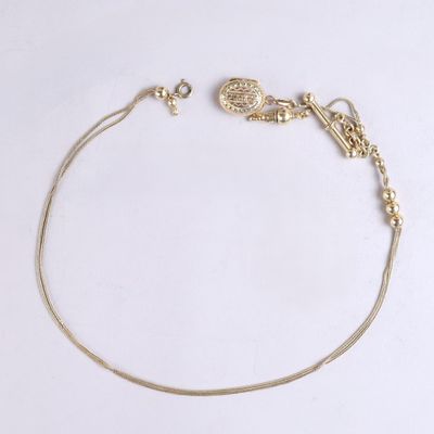 a close up of a gold chain bracelet on a white surface
