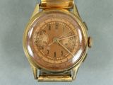 une montre en or avec un cadran marron et un bracelet en or